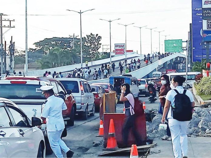 Traffic congestion has driven commuters to forcibly open the closed half-a-kilometer-long Ungka flyover and walk through it on Feb. 6, 2023. CEDRICK ANONA PHOTO