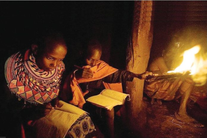 Children study at night using a flame on a stick in their manyatta [mud-thatch home] at Kisima in Samburu County, approximately 350 kilometers north of Nairobi, Kenya. AFP