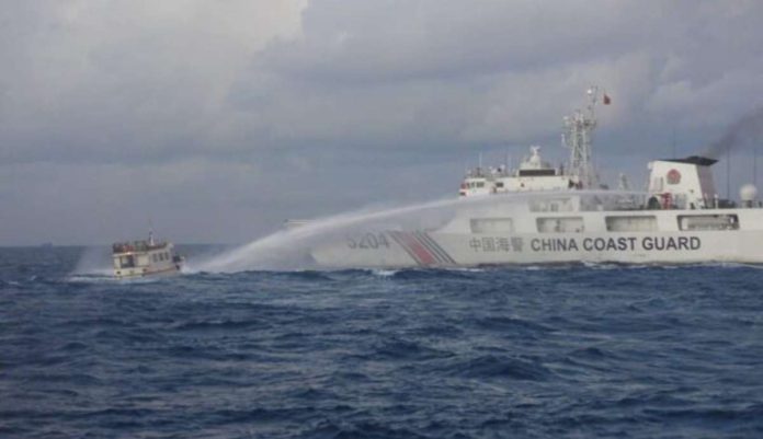 A Chinese military vessel fires a water cannon at Philippine boat M/L Kalayaan during a resupply mission in Ayungin (Second Thomas) Shoal in the West Philippine Sea on Dec. 10, 2023. The boat had to be towed back to port without completing its mission due to significant damage from the attack. PHOTO FROM PCG