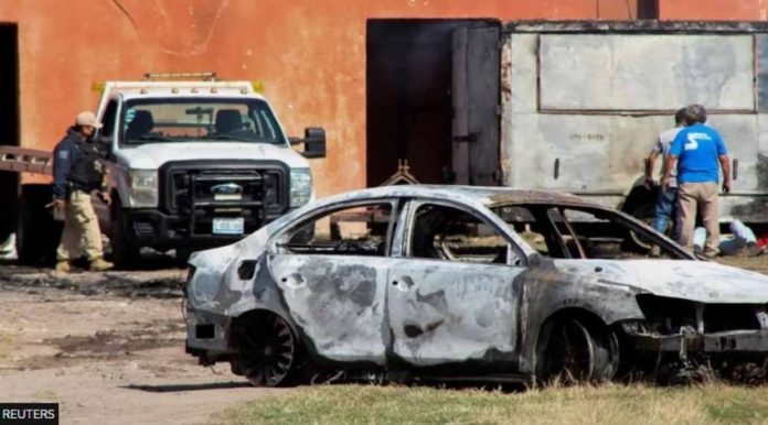 The burnt wreckage of a car stands at the scene where members of an armed group opened fire to partygoers attending a posada, in Salvatierra, in Guanajuato state, Mexico. REUTERS