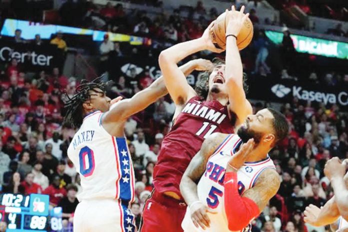 Miami Heat rookie Jaime Jaquez Jr. attacks the defense of Philadelphia 76ers' Tyrese Maxey and Marcus Morris Sr. for an inside hit. PHOTO COURTESY OF LYNNE SLADKY/AP