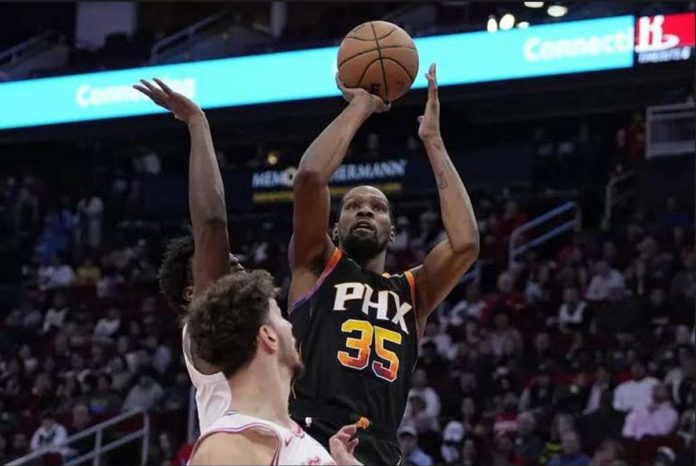 Phoenix Suns' Kevin Durant pulls up for a basket against two Houston Rockets' defenders. PHOTO COURTESY OF KEVIN COX/AP PHOTO