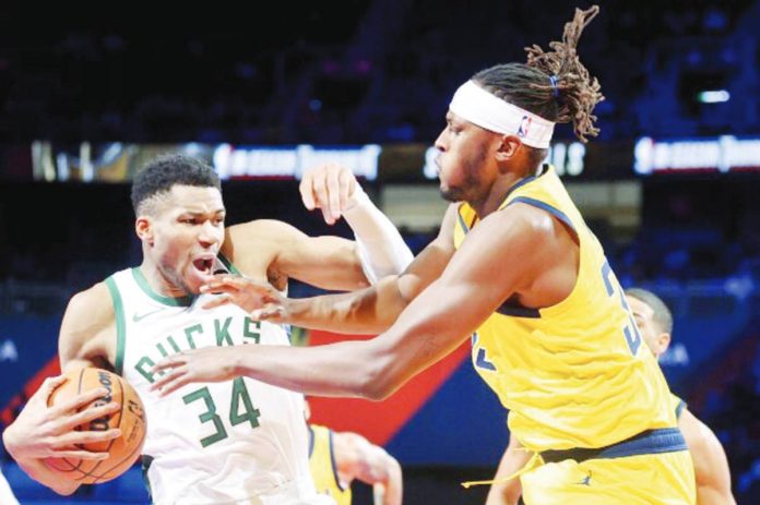 Indiana Pacers’ Myles Turner attempts to grab the ball from Milwaukee Bucks' Giannis Antetokounmpo. AP Photo. AP PHOTO