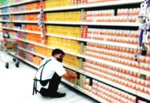 A worker arranges canned goods on the shelves in a grocery store in Quezon City in this undated photo. The Philippine Amalgamated Supermarkets Association on Tuesday, Dec. 5, said suppliers of basic commodities have not made significant adjustments to the prices of their goods. PNA PHOTO BY BEN BRIONES