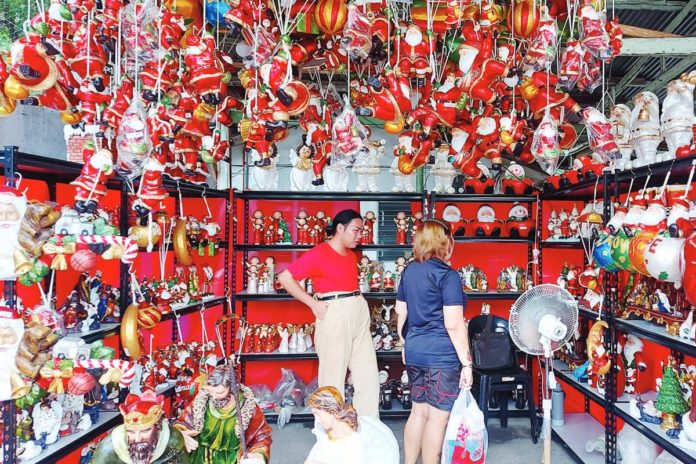 A customer checks out the various hanging Christmas toys and decors such as Santa Clausses, angels, candy canes, and other holiday season ornaments on sale in this shop along JP Laurel Avenue in Davao City. PNA