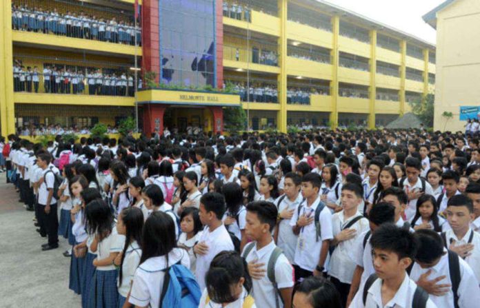 High school students attend a flag raising ceremony at a government school in Quezon City. AFP