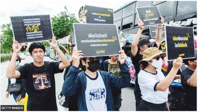 Thai Amnesty International activists hold placards during a demonstration in Bangkok calling for the release of political prisoners convicted under the lese majeste law. GETTY IMAGES