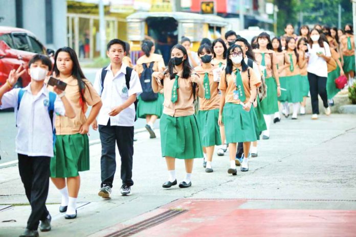 Students of the Quezon City High School troop to their school along Scout Ybardolaza Street, Barangay Sacred Heart, Quezon City. The Department of Education says there are over 22.9 million students from public and private schools from kindergarten to senior high school in school year 2023-2024. PNA