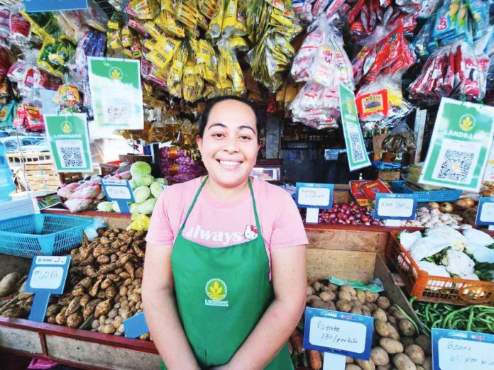 Iloilo Terminal Market vegetable stall owner Jasmin Marasigan now accepts cashless payments via QR code powered by LANDBANK.