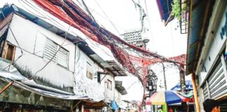 Electrical cables crisscross one another as electric meters hang on posts in Barangay Old Capitol, Quezon City on July 11, 2023. MARIA TAN/ABS-CBN NEWS PHOTO