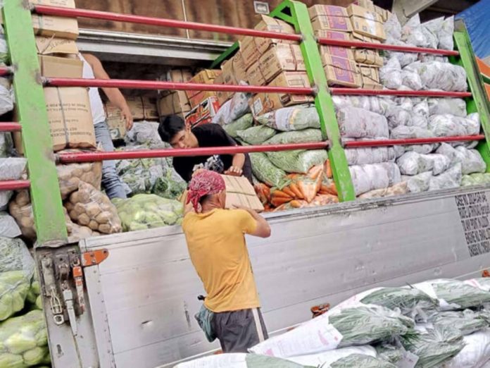 Workers at the vegetable trading post in La Trinidad, Benguet, keep up with the arrival of delivery trucks unloading freshly harvested vegetables from farms in the province and other areas in the Cordillera region. File photo by ALLAN MACATUNO / Inquirer Northern Luzon