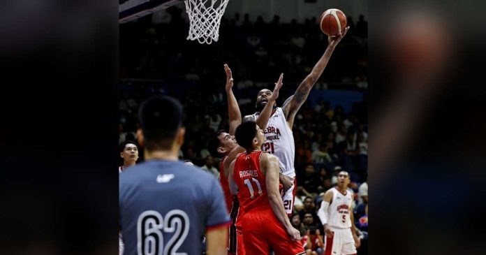 Barangay Ginebra San Miguel Kings’ Tony Bishop Jr. attempts a hook shot against the defense of NorthPort Batang Pier’s Benedict Adamos. PBA PHOTO