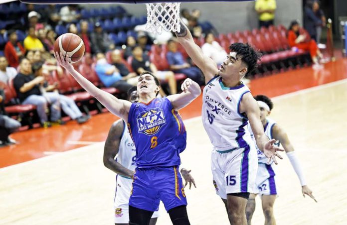 NLEX Road Warriors’ Robert Bolick Jr. goes for a layup against the defense of Converge FiberXers’ Justin Arana. PBA PHOTO