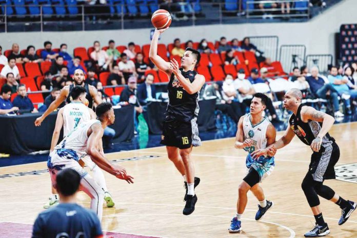 TNT Tropang Giga’s Roger Pogoy scores on a floater against the defense of Phoenix Super LPG Fuel Masters’ Johnathan Williams III. PBA PHOTO