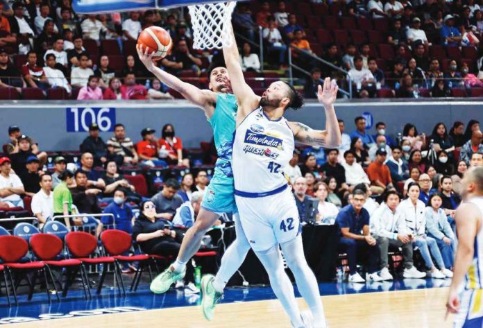 Phoenix Super LPG Fuel Masters’ Javee Mocon goes for a tough basket against the defense of Magnolia Chicken Timplados Hotshots’ James Laput. PBA PHOTO