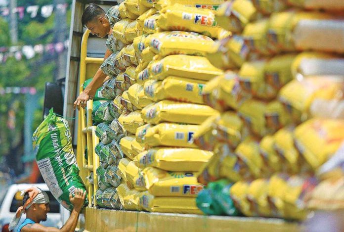 The Philippines is currently estimated to import 3.8 million metric tons of rice this year. Photo shows workers unloading sacks of premium rice from a truck parked on Dagupan Street in Divisoria Market, Manila. DANNY PATA PHOTO