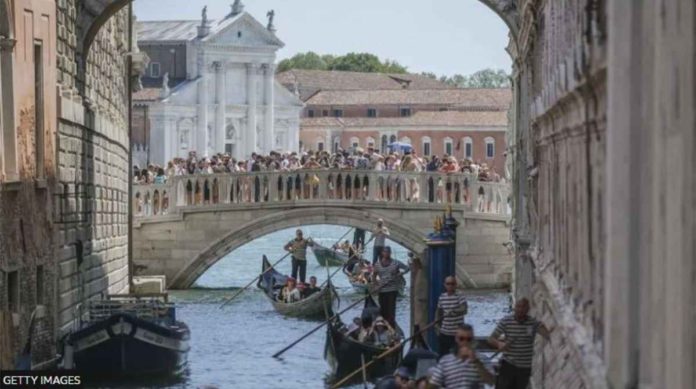 Gondolas slowly pass under the Bridge of Sighs near St. Mark’s Square due to too much traffic in Venice. GETTY IMAGES