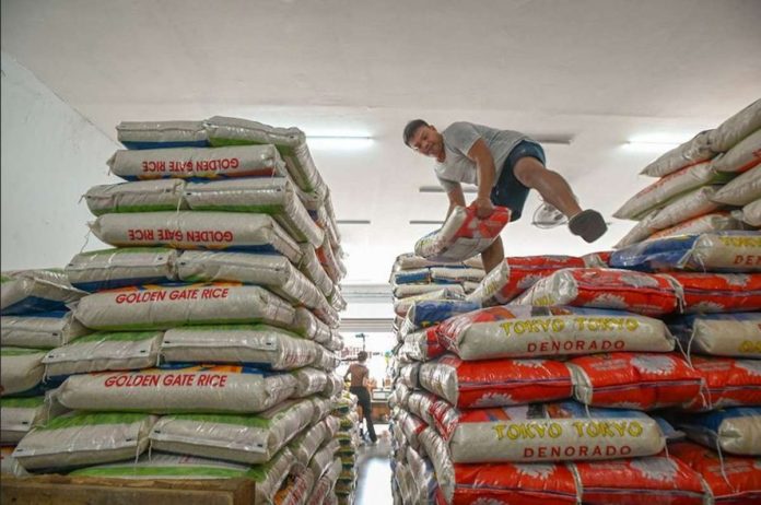 A worker arranges sacks of rice at a local rice store in Quezon City. ABS-CBN NEWS PHOTO