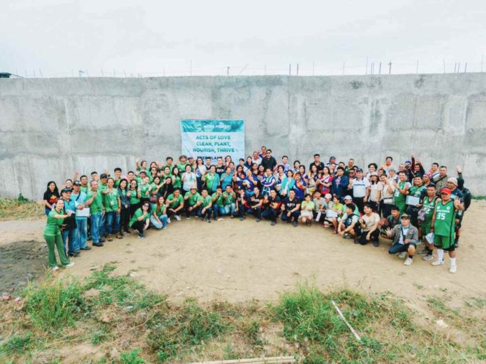 MORE Electric and Power Corporation employees proudly do the four-finger sign, symbolizing their four years of operation in Iloilo City since 2020, following a tree planting activity.