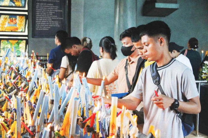 Devotees of Nuestra Señora de la Candelaria light perdon candles at the Jaro Metropolitan Cathedral. They believe that these candles are miraculous and should be lit in times of need, especially during calamities, for protection. AJ PALCULLO/PN