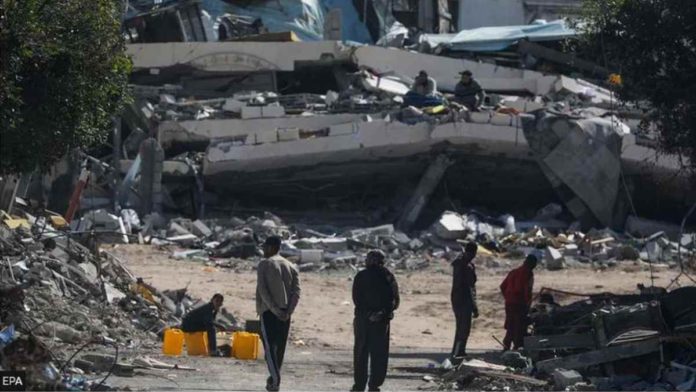 People walk next to destroyed houses in the Gaza Strip. EPA