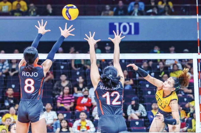 Far Eastern University Lady Tamaraws’ Gerzel Petallo slams the ball towards two University of the East Lady Warriors defenders. UAAP PHOTO