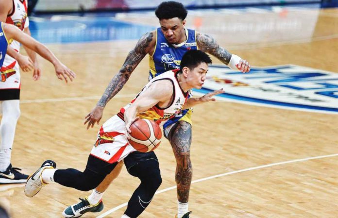 San Miguel Beermen’s Jeron Teng dribbles the ball away from the defense of Magnolia Chicken Timplados Hotshots’ Tyler Bey. PBA PHOTO