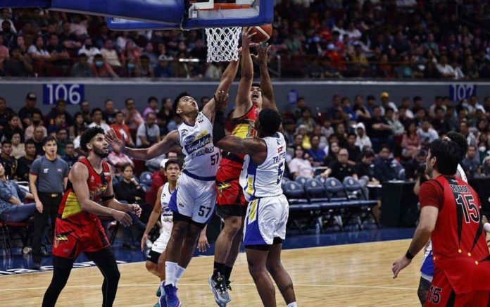 San Miguel Beermen’s Celedonio Trollano goes for a layup against the defense of Magnolia Chicken Timplados Hotshots’ Aris Dionisio and Abu Tratter. PBA PHOTO