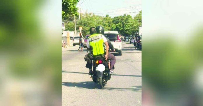 This Bacolod Traffic Authority Office enforcer was seen backriding on a motorcycle with no helmet. CONTRIBUTED PHOTO
