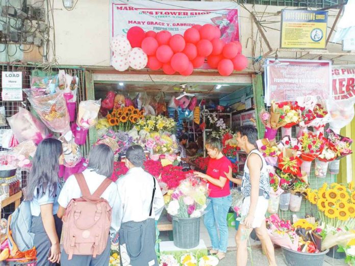 Flowers reign as the quintessential gifts for Valentine's Day. In Iloilo City, roses and carnations stand out not only for their beauty but also for their affordability, with prices ranging from P100 to P150 per stem. This photo captures a moment in the City Proper, where numerous students gather at a local flower shop, exploring their options for the perfect Valentine's Day gesture. AJ PALCULLO/PN