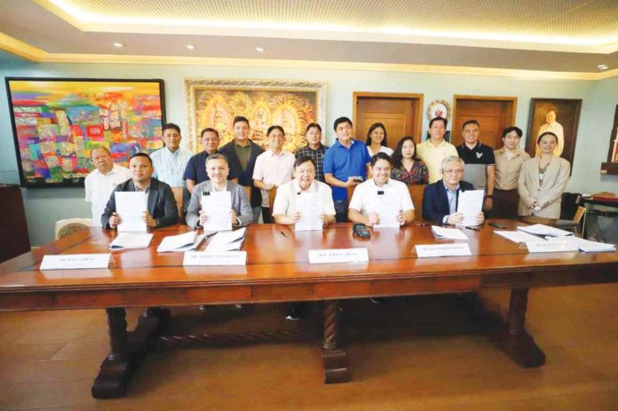 Mayor Jerry Treñas and Metro Pacific Water Investments Corporation president and chief executive officer Andrew Pangilinan lead the ceremonial contract exchange on Friday, March 1, 2024, for the construction of a state-of-the-art Integrated Solid Waste Management Facility in Iloilo City. ILOILO CITY MAYOR’S OFFICE PHOTOS