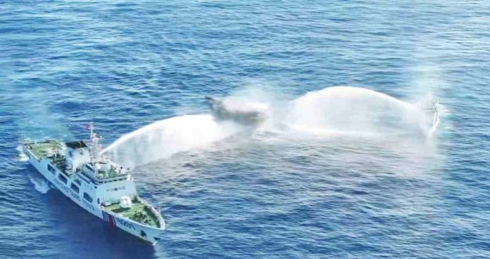 Manila has asked Beijing to order all its vessels to leave Ayungin Shoal following the “dangerous maneuvers” made by the China Coast Guard (CCG) to block Philippine ships headed for the BRP Sierra Madre on Tuesday. An image from aerial footage released by the Philippine Coast Guard shows two CCG vessels blasting their water cannons at Unaizah May 4 (center). AFP PHOTO / PHILIPPINE COAST GUARD