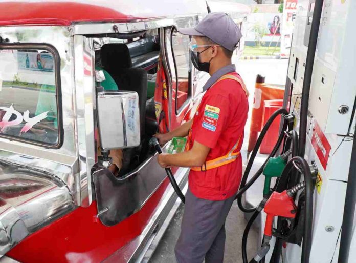 A pump attendant fills up a public utility jeepney at a gasoline station along Samano Road, Camarin, Caloocan. Oil companies will lower prices per liter of gasoline by P0.50, diesel by P0.25, and kerosene by P0.30. effective today, March 12. PNA PHOTO BY BEN BRIONES