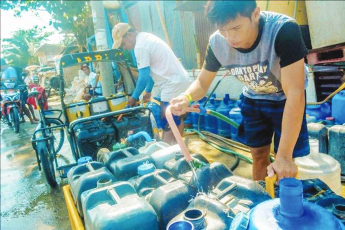 The Iloilo Provincial Disaster Risk Reduction and Management Office says the drop in water supply may likely to persist until May this year. photo shows a man filling plastic containers with water in Lapuz, Iloilo City. PN FILE PHOTO