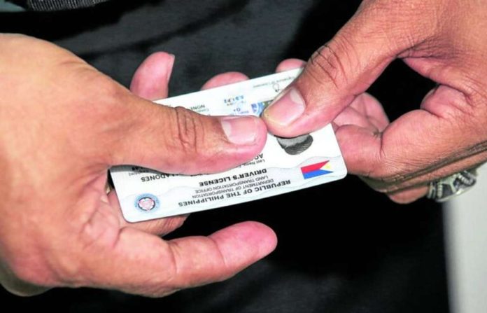 A Land Transportation Office (LTO) staff member shows a brand new student driver’s license at the LTO Quezon City District Office in Centris Station. The LTO had been facing a supply shortage of plastic cards for driver’s licenses. INQUIRER PHOTO/LYN RILLON