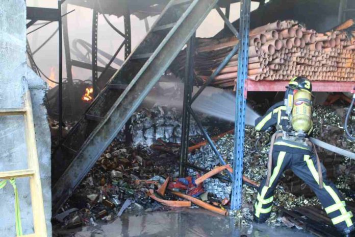 A firefighter extinguishes the fire that razed a warehouse in Barangay Guihaman, Leganes, Iloilo on Thursday afternoon, April 4. AJ PALCULLO/PN