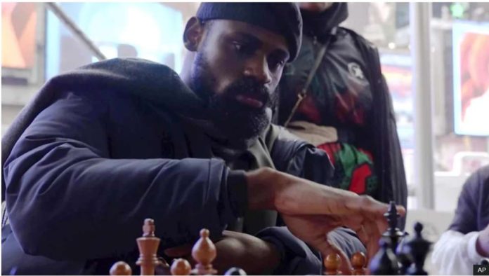 In this screen grab taken from video, Tunde Onakoya, a Nigerian chess champion and child education advocate, play a chess game in Times Square, New York. AP