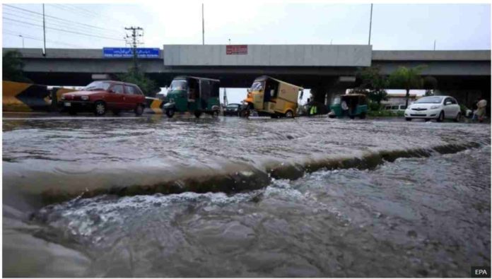 People make their way during heavy rain in Peshawar, Pakistan. With more rain expected in the coming days, Pakistani authorities have also warned of landslides and flash floods. EPA