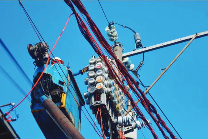 Workers inspect an electric meter installed above ground in Manila on January 11, 2024. MARK DEMAYO/ABS-CBN NEWS PHOTO