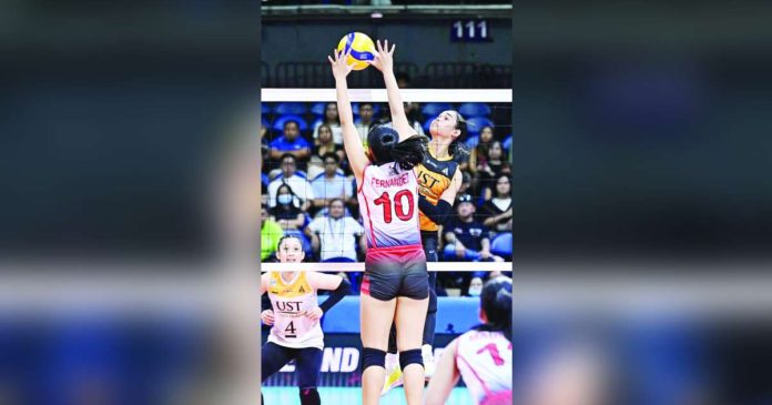 University of Santo Tomas Golden Tigresses’ Angeline Poyos smashes the ball towards the University of the East Lady Warriors defense. UAAP PHOTO