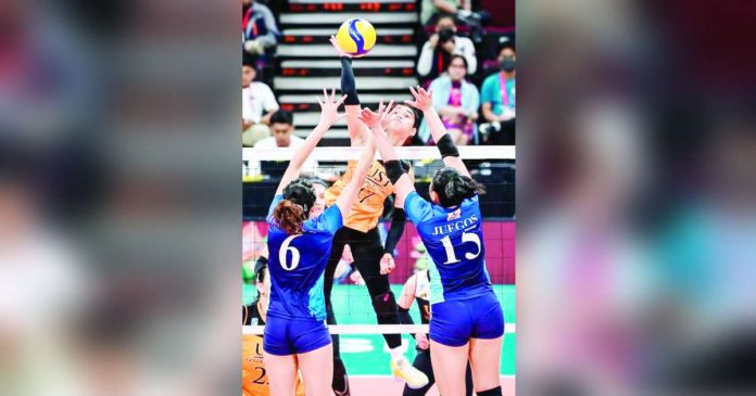 University of Santo Tomas Golden Tigresses rookie Angeline Poyos scores against the double-block defense of Adamson University Lady Falcons. UAAP PHOTO