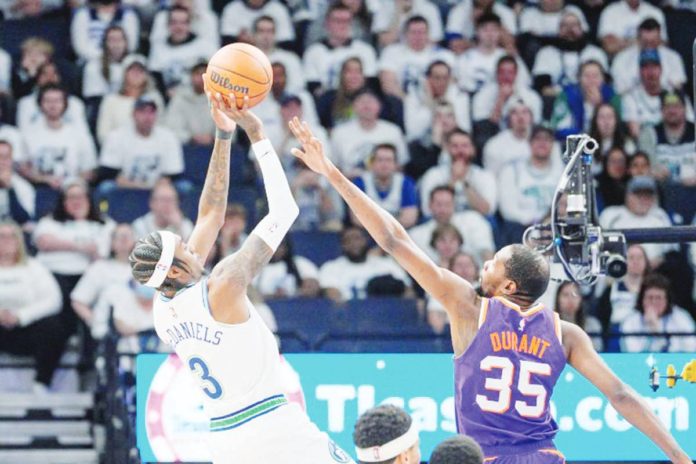 Minnesota Timberwolves’ Jaden McDaniels (3) shoots against Phoenix Suns’ Kevin Durant (35). BRAD REMPEL-USA TODAY SPORTS