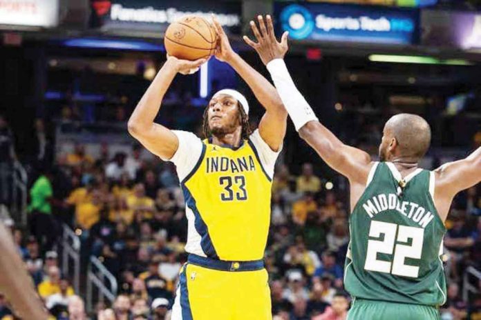 Indiana Pacers’ Myles Turner (33) shoots the ball while Milwaukee Bucks’ Khris Middleton (22) defends. TREVOR RUSZKOWSKI/USA TODAY SPORTS