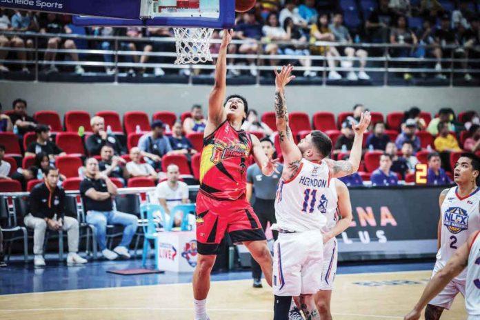 San Miguel Beermen’s Celedonio Trollano goes for a layup against the defense of NLEX Road Warriors’ Robbie Herndon. PBA PHOTO