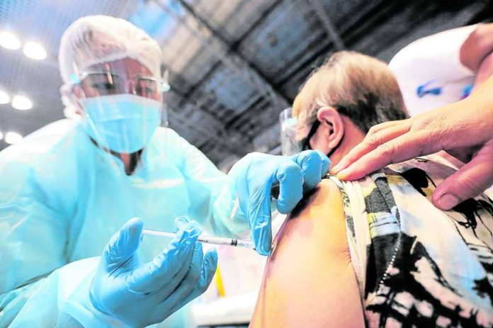 A nurse vaccinates a senior citizen who ignored claims against COVID-19 vaccines. INQUIRER FILE PHOTO