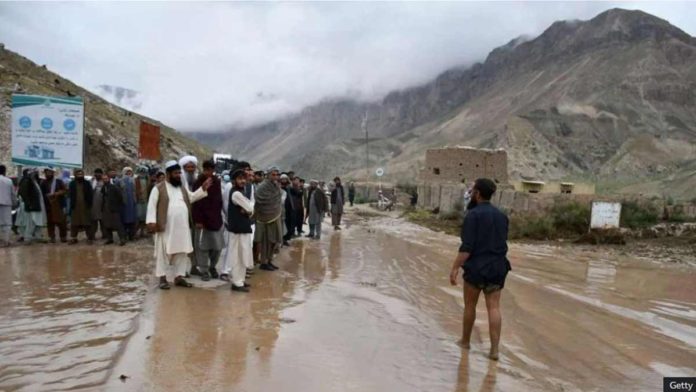 Afghans gather along a road between Samangan and Mazar-i-Sharif covered in mud following a flash flood after a heavy rainfall. GETTY IMAGES