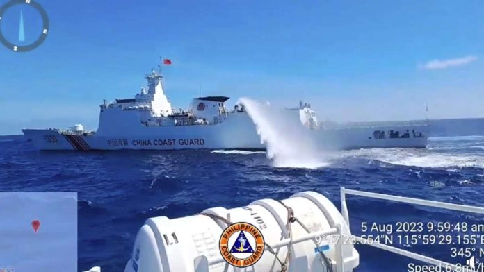 A China Coast Guard ship fires its water cannon at Philippine Coast Guard (PCG) vessels escorting supply boats chartered by the Armed Forces of the Philippines in this August 2023 photo. The Philippine boats were delivering supplies to troops at BRP Sierra Madre in Ayungin (Second Thomas) Shoal when confronted by the Chinese. VIDEOGRAB FROM PCG FACEBOOK PAGE