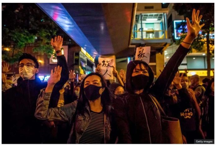 People chant slogans near a Hong Kong police-cordoned-area to show support for a small group of protesters. GETTY IMAGES