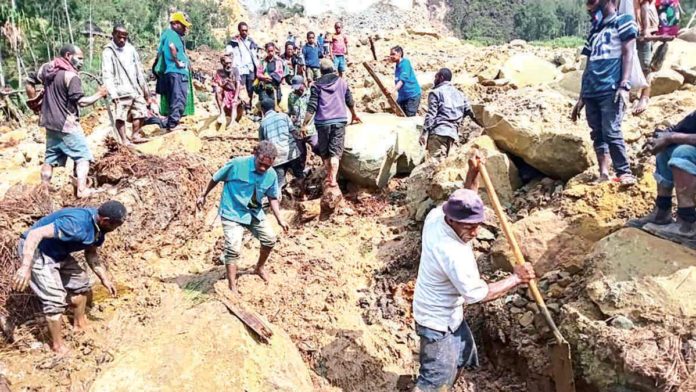 Villagers in Yambali, Papua New Guinea dig rubbles and mud hoping to find survivors following a landslide. AP