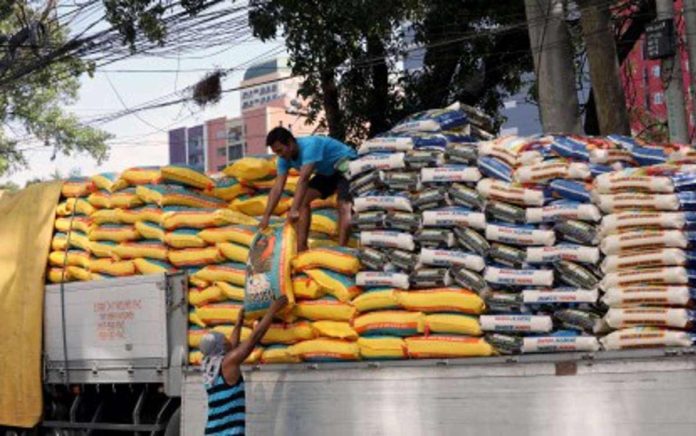 Workers unload sacks of rice at a warehouse in Tondo, Manila in this undated photo. Finance Secretary Ralph Recto has proposed the further reduction of rice import tariff to further lower rice prices. PNA PHOTO BY YANCY LIM